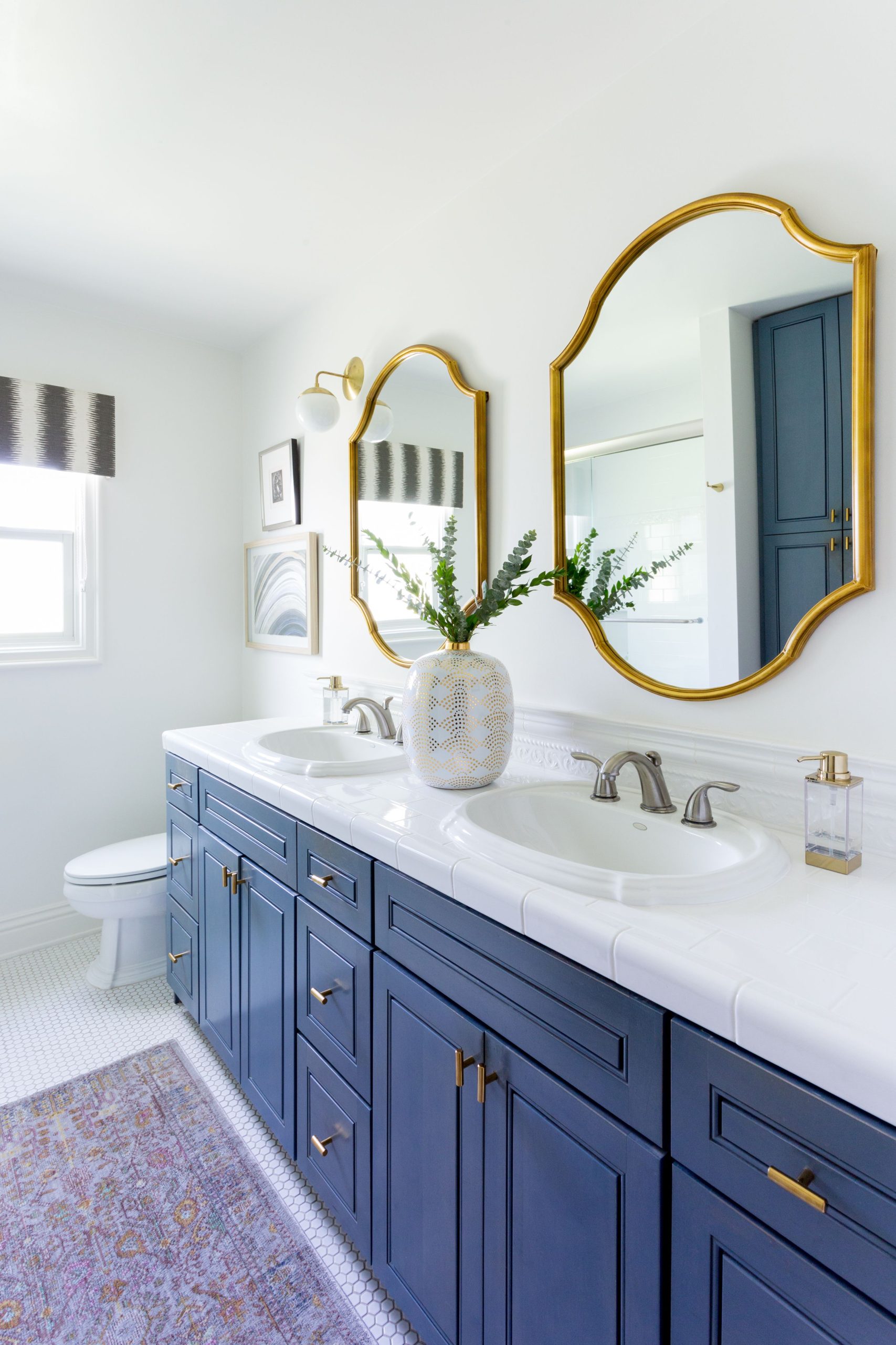 Blue and white bathroom + gold framed mirrors + his and her sinks