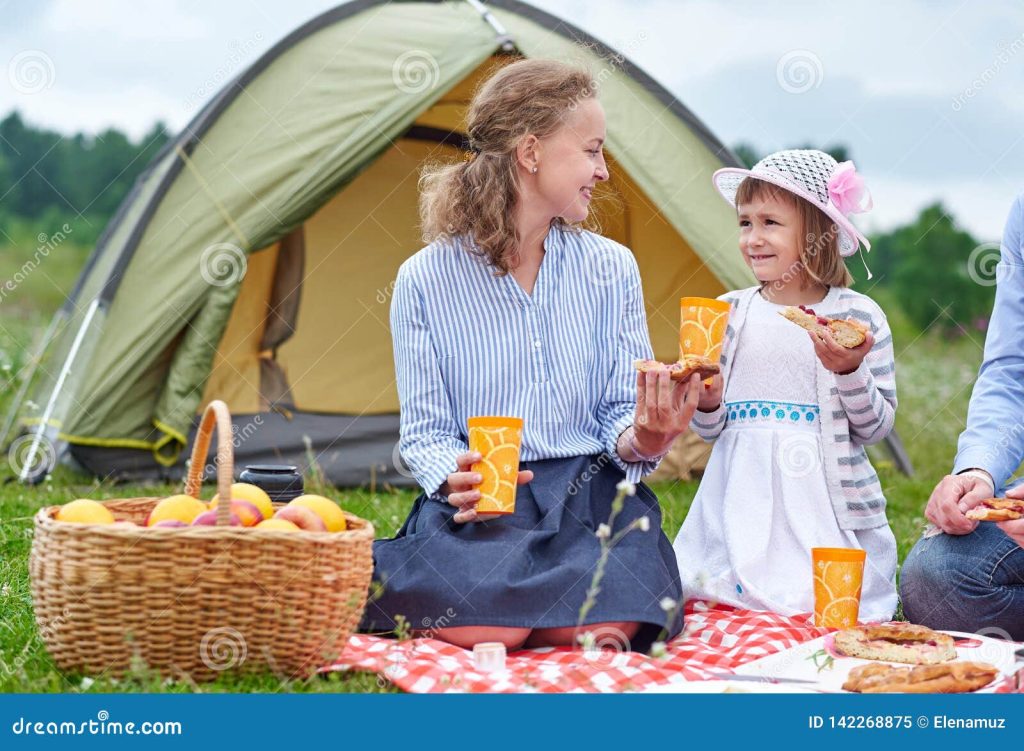Happy Family on Picnic at Camping. Mother and Daughter Eating Near a
