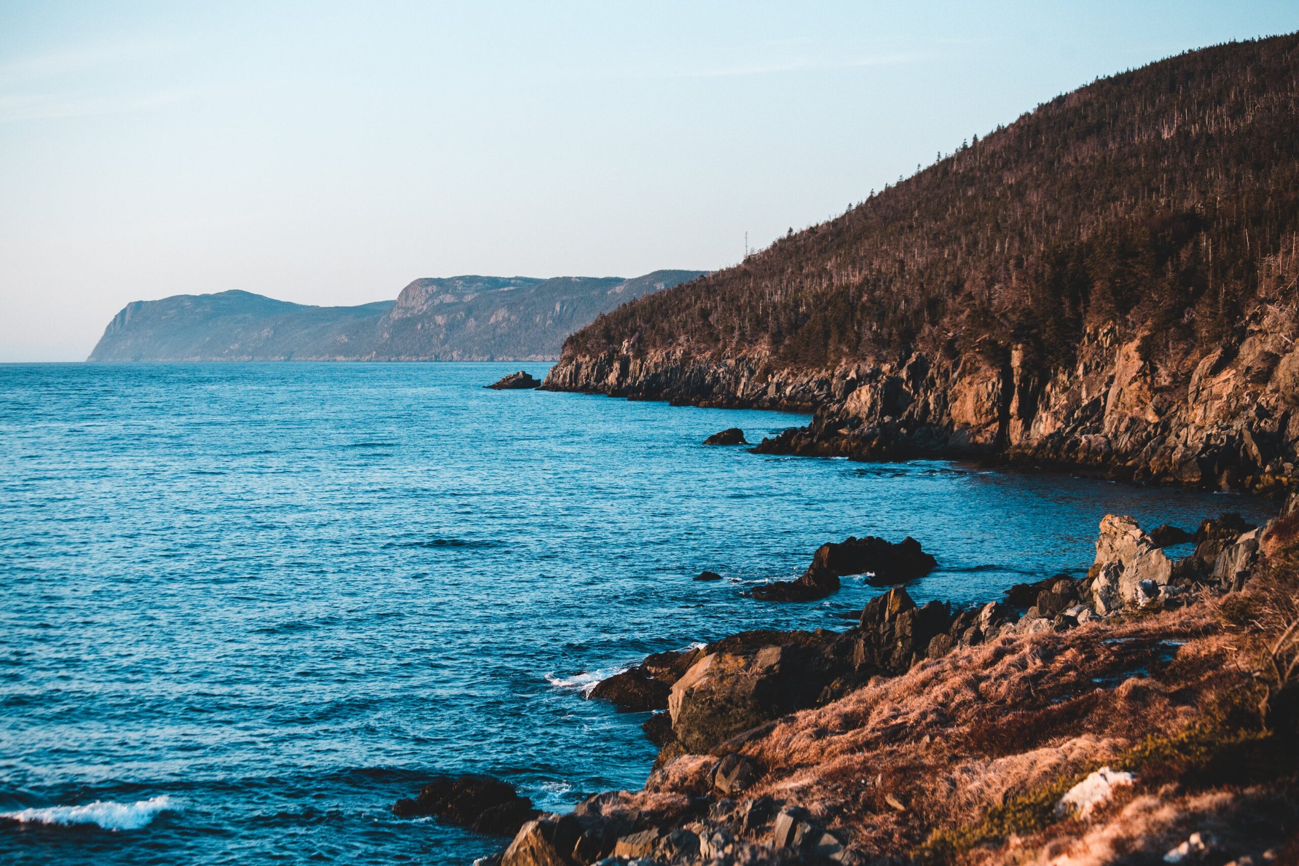 Cliff ridge above serene sea · Free Stock Photo